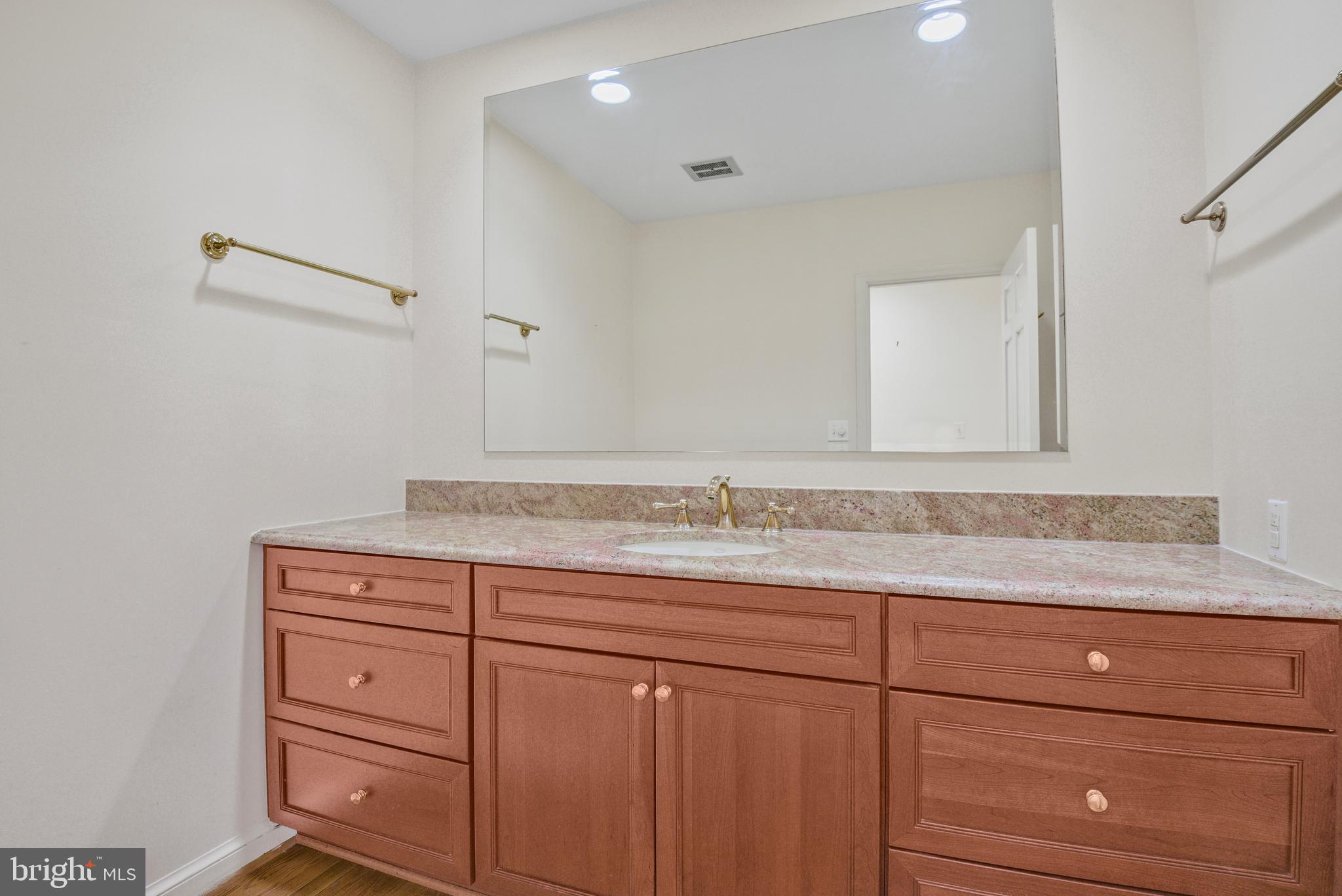 10101 Bentcross Drive Potomac, MD 20854 - Photo 20 of 44 a bathroom with a granite countertop sink and mirror