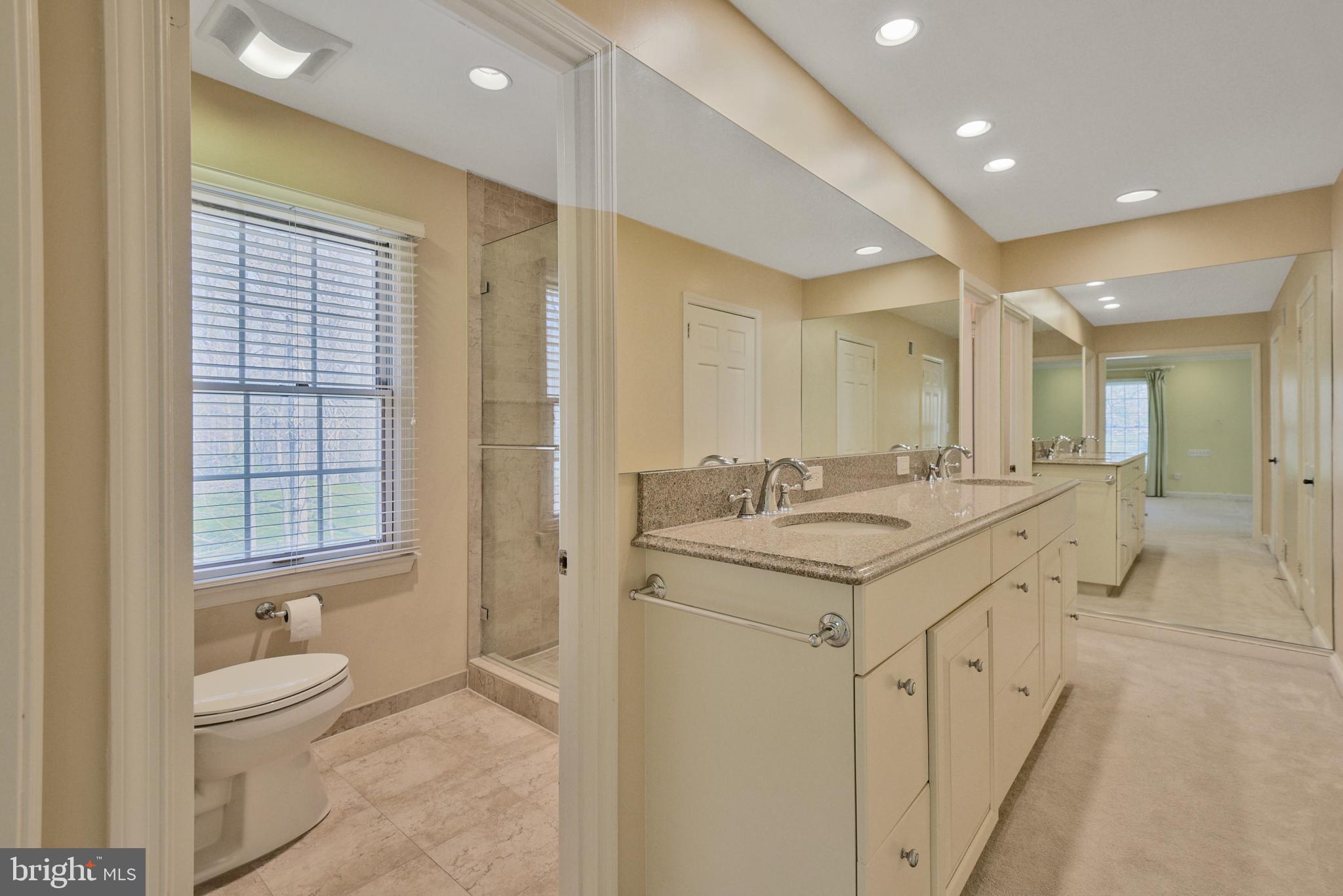 10101 Bentcross Drive Potomac, MD 20854 - Photo 24 of 44 a spacious bathroom with a granite countertop sink a toilet and a shower