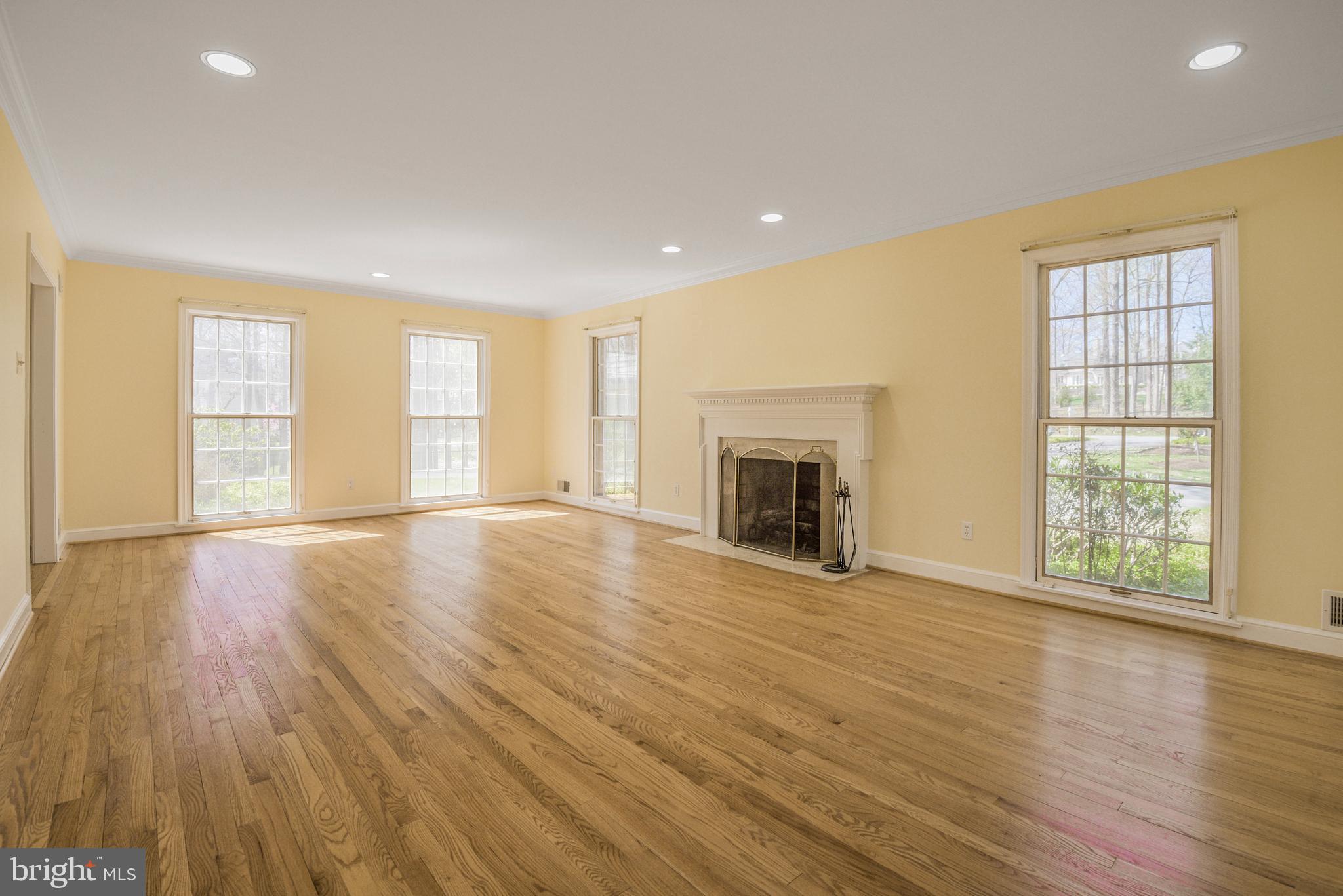 10101 Bentcross Drive Potomac, MD 20854 - Photo 8 of 44 an empty room with wooden floor fireplace and windows