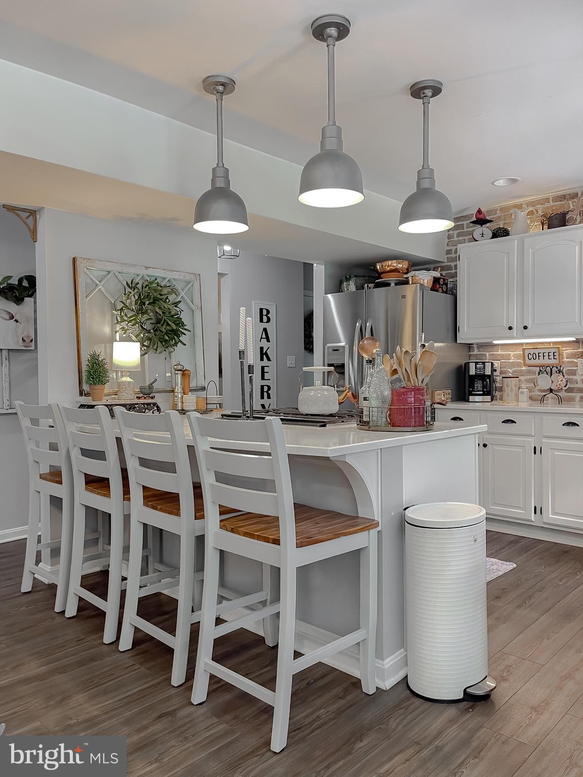 22338 White Oak Road Leonardtown, MD 20650 - Photo 23 of 66 a kitchen with stainless steel appliances a dining table chairs and white cabinets