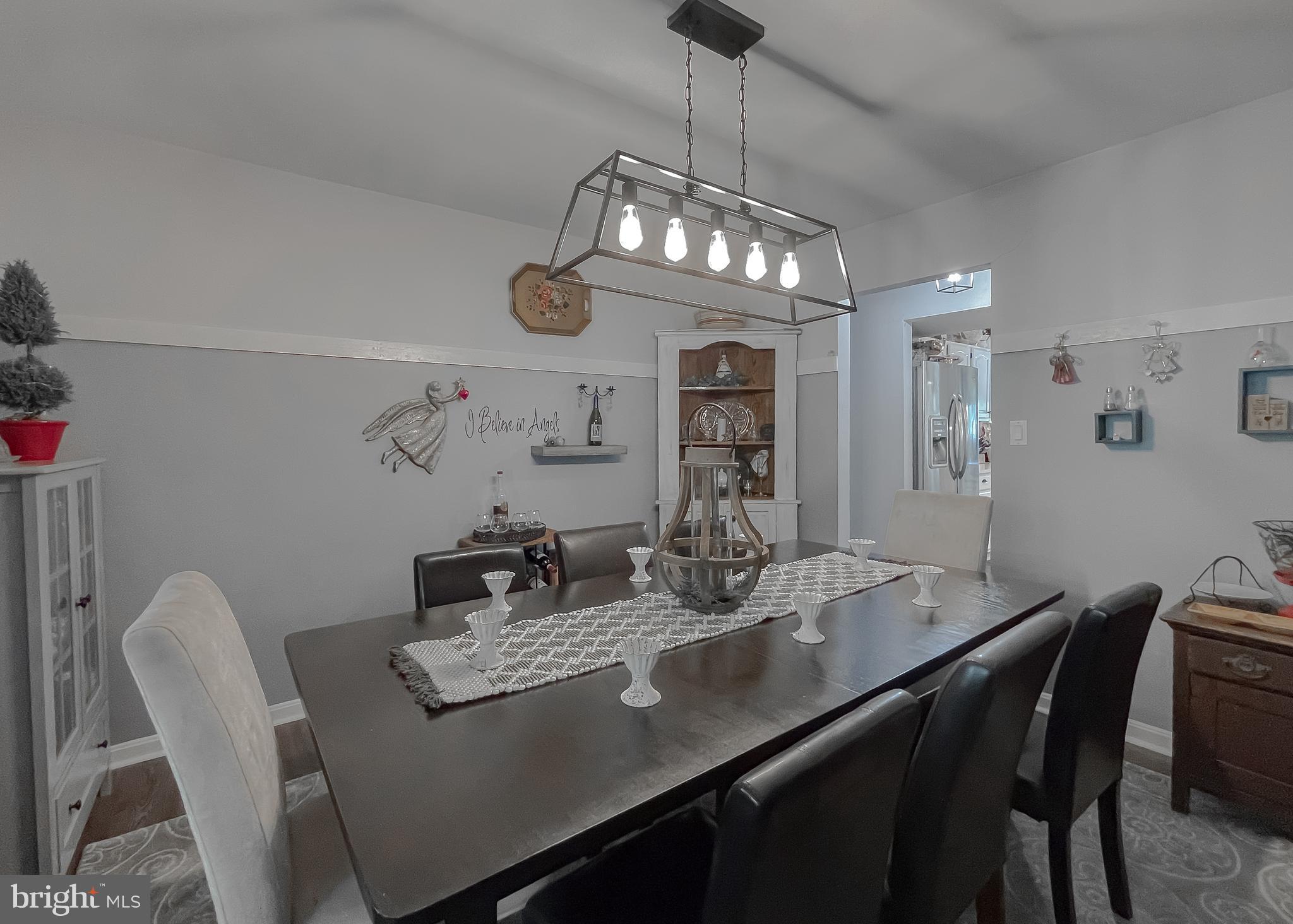 22338 White Oak Road Leonardtown, MD 20650 - Photo 26 of 66 a view of a dining room with furniture a chandelier and wooden floor