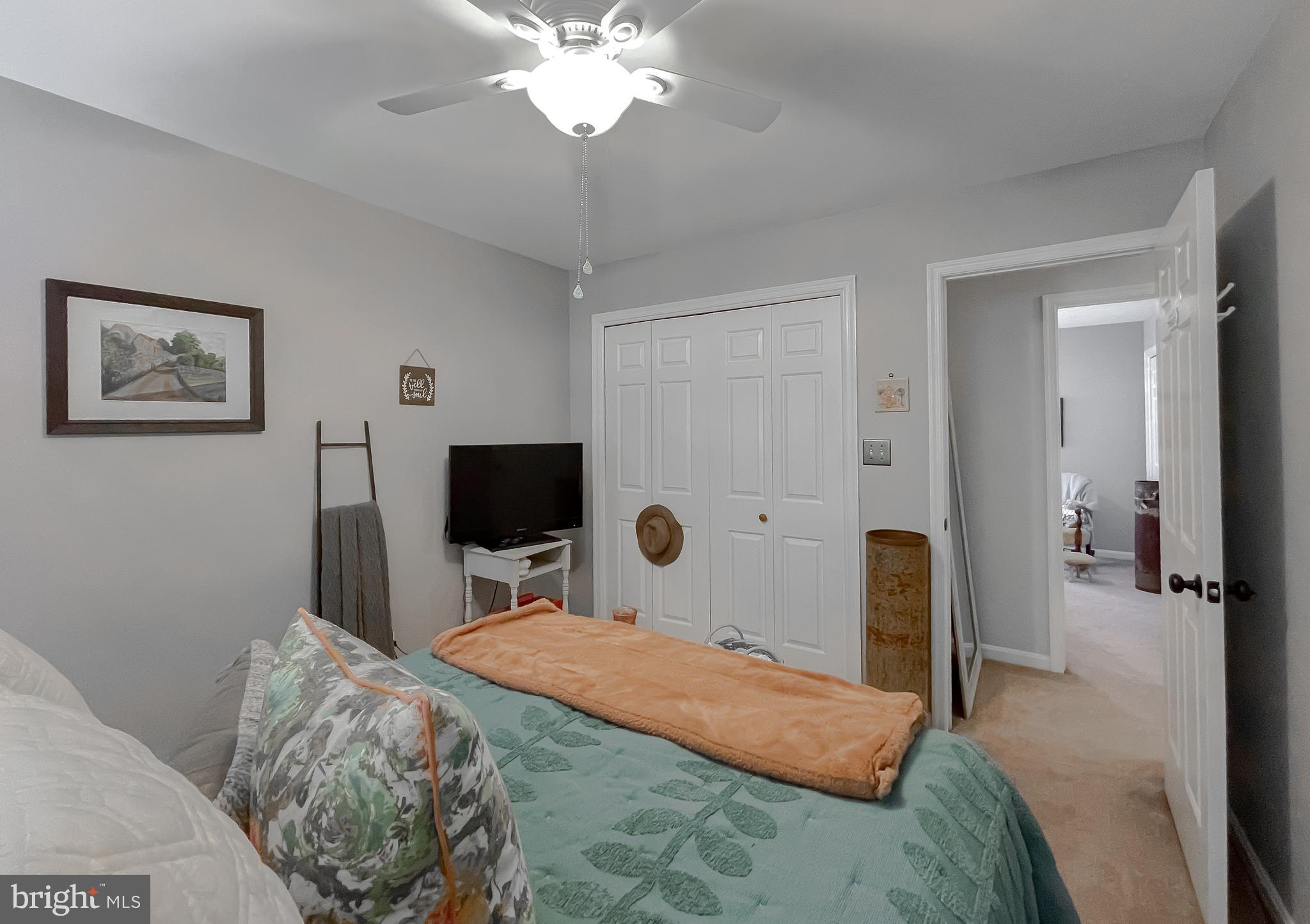 22338 White Oak Road Leonardtown, MD 20650 - Photo 30 of 66 a bedroom with a large bed and a chandelier