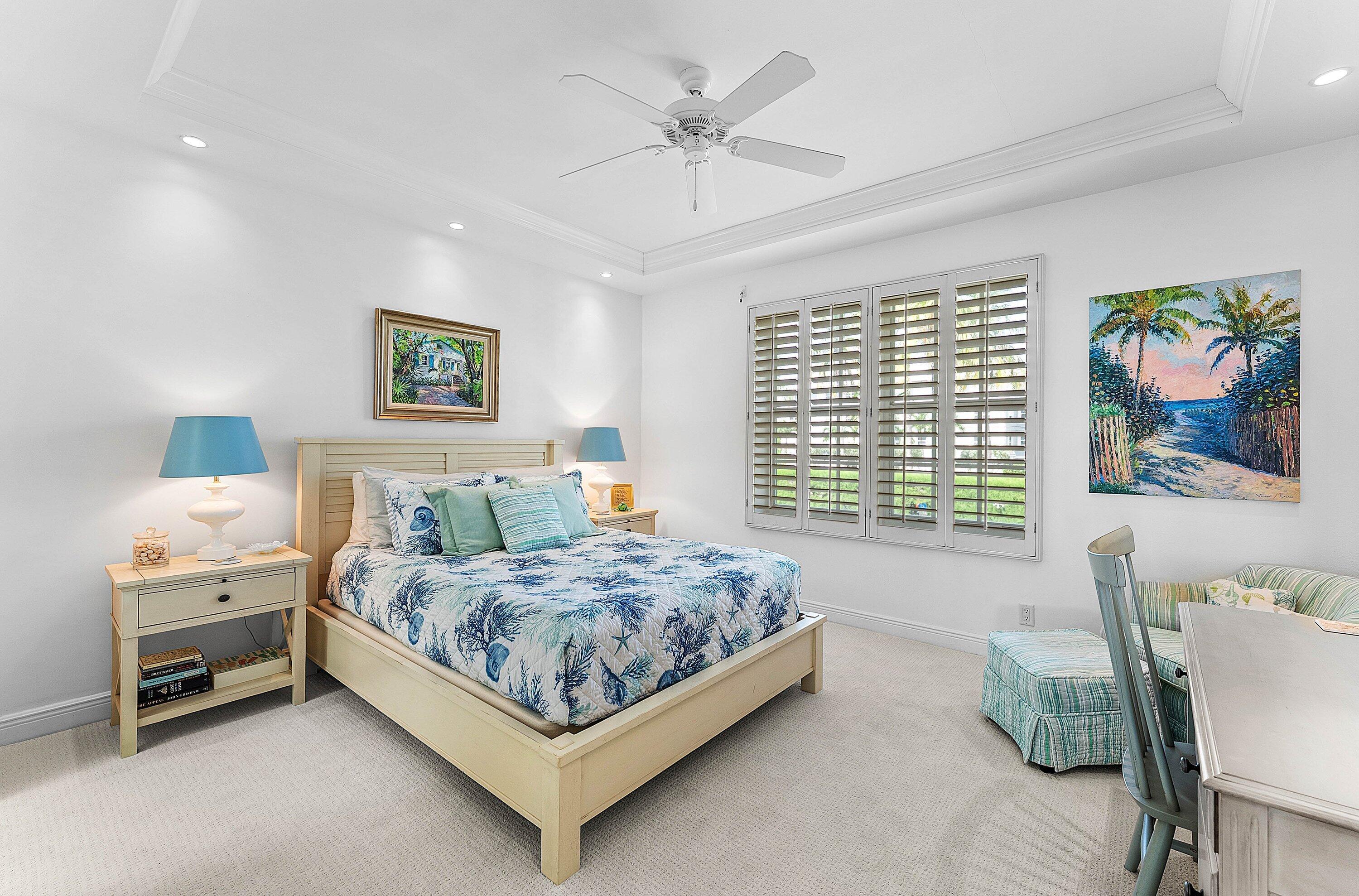 2103 South Ocean Boulevard, Unit 4B Delray Beach, FL 33483 - Photo 21 of 46 a bedroom with a bed and a chandelier
