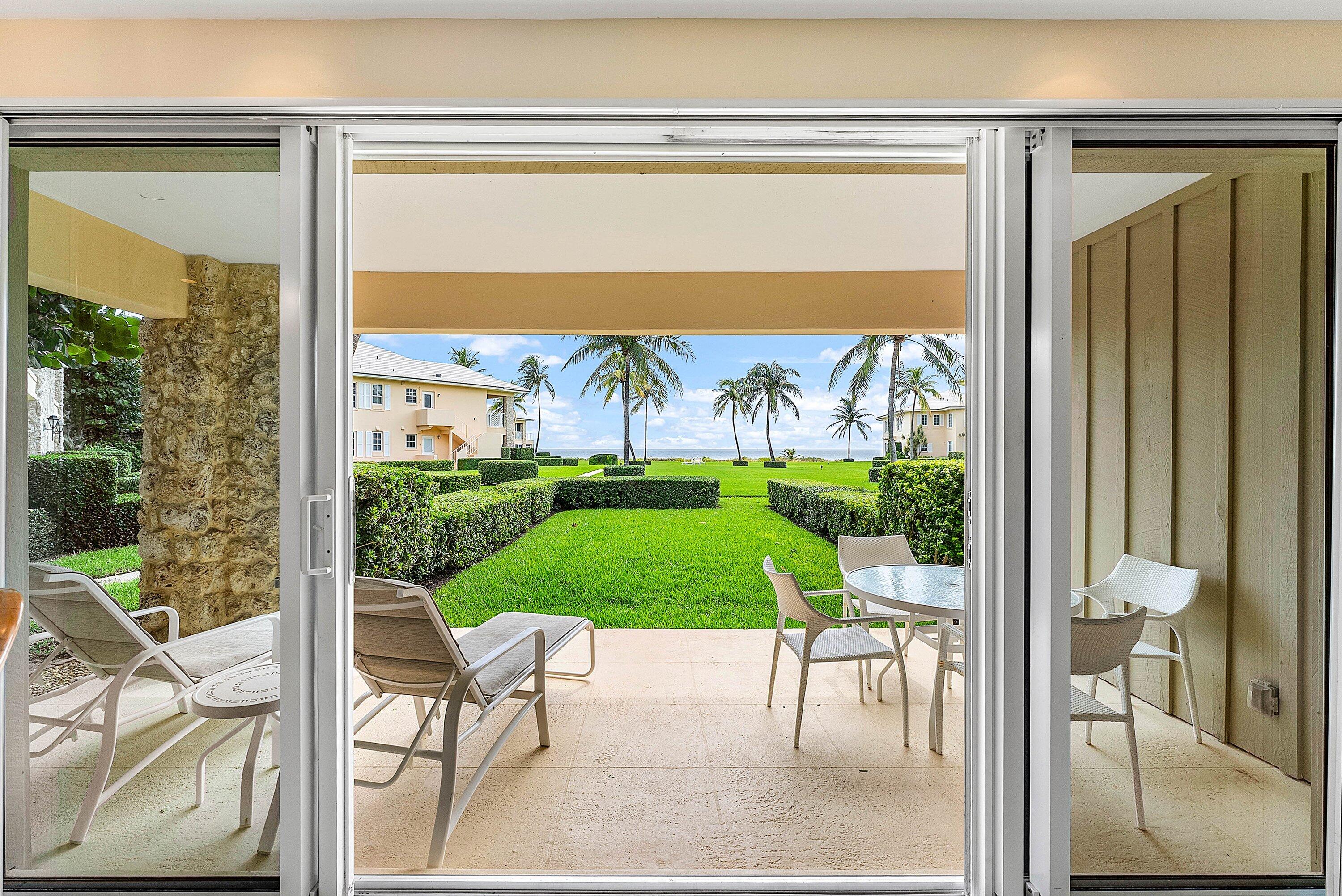 2103 South Ocean Boulevard, Unit 4B Delray Beach, FL 33483 - Photo 3 of 46 a view of a patio with a table chairs and a yard