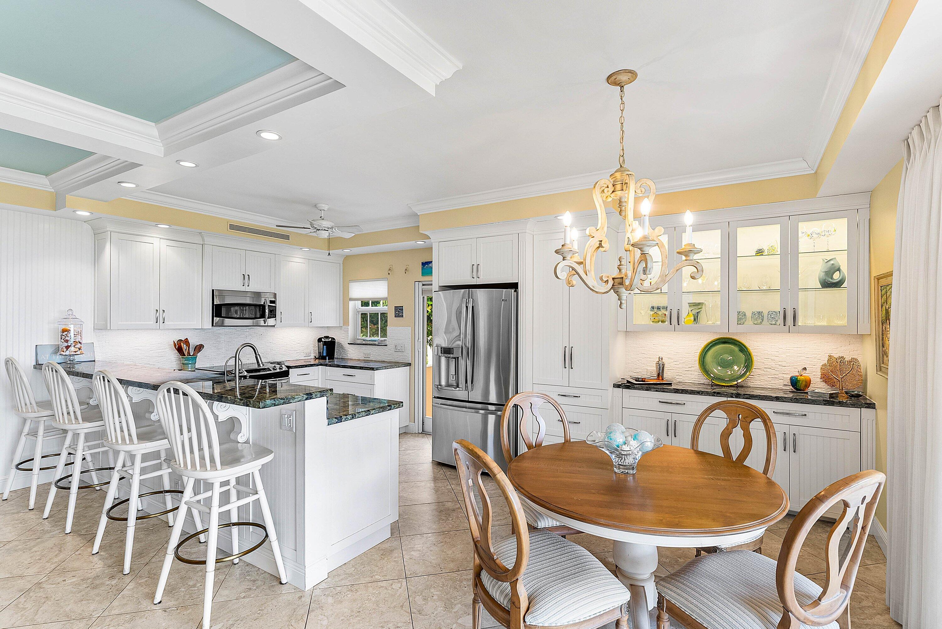 2103 South Ocean Boulevard, Unit 4B Delray Beach, FL 33483 - Photo 8 of 46 a dining room with furniture a chandelier and wooden floor