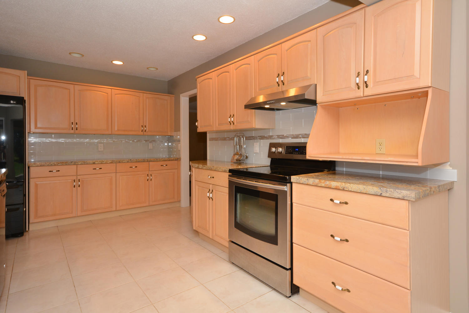200 North Country Club Boulevard Boca Raton, FL 33487 - Photo 11 of 27 a kitchen with stainless steel appliances granite countertop a stove a sink and a refrigerator with cabinets