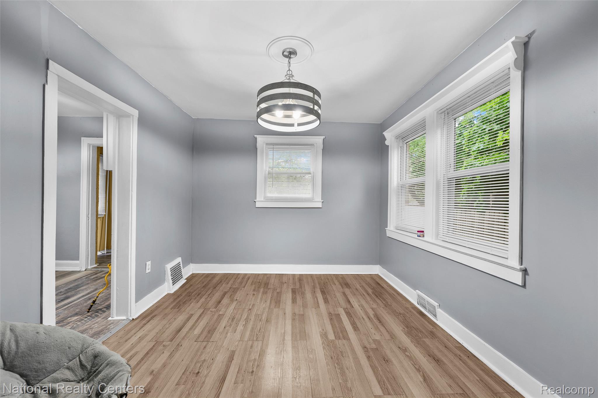 686 Perry Street Pontiac, MI 48342 - Photo 9 of 26 Unfurnished dining area featuring light wood-type flooring and suspended lighting