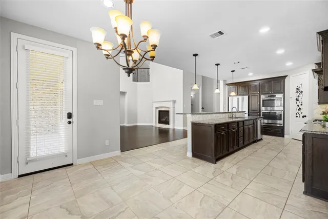 a large white kitchen with a large counter top stainless steel appliances and cabinets
