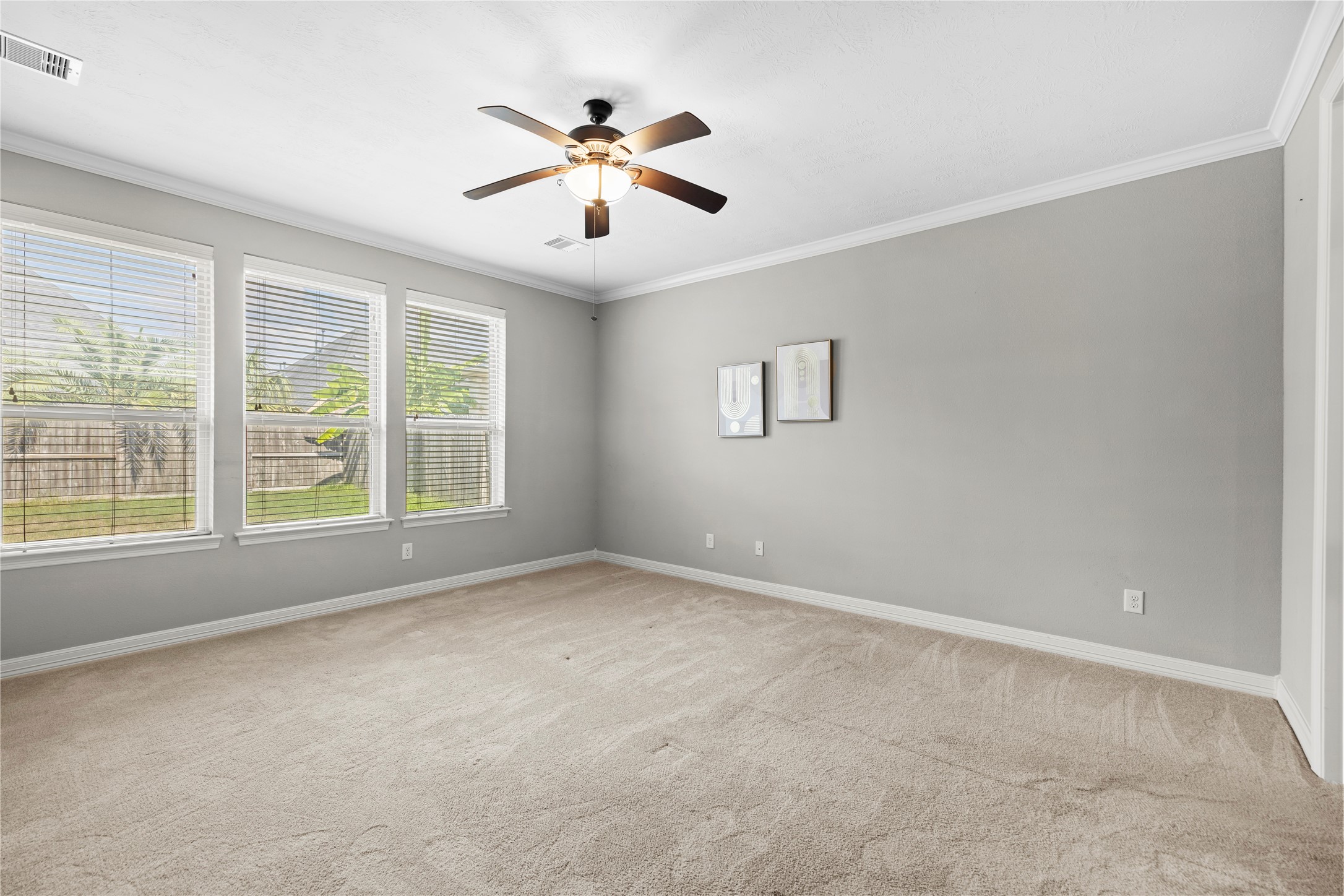 27506 Windcrest Key Lane Fulshear, TX 77441 - Photo 17 of 30 an empty room with windows and chandelier fan