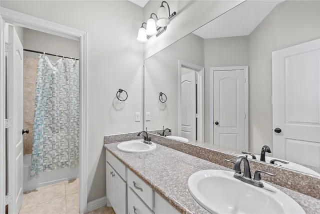 a bathroom with double vanity sinks and a mirror
