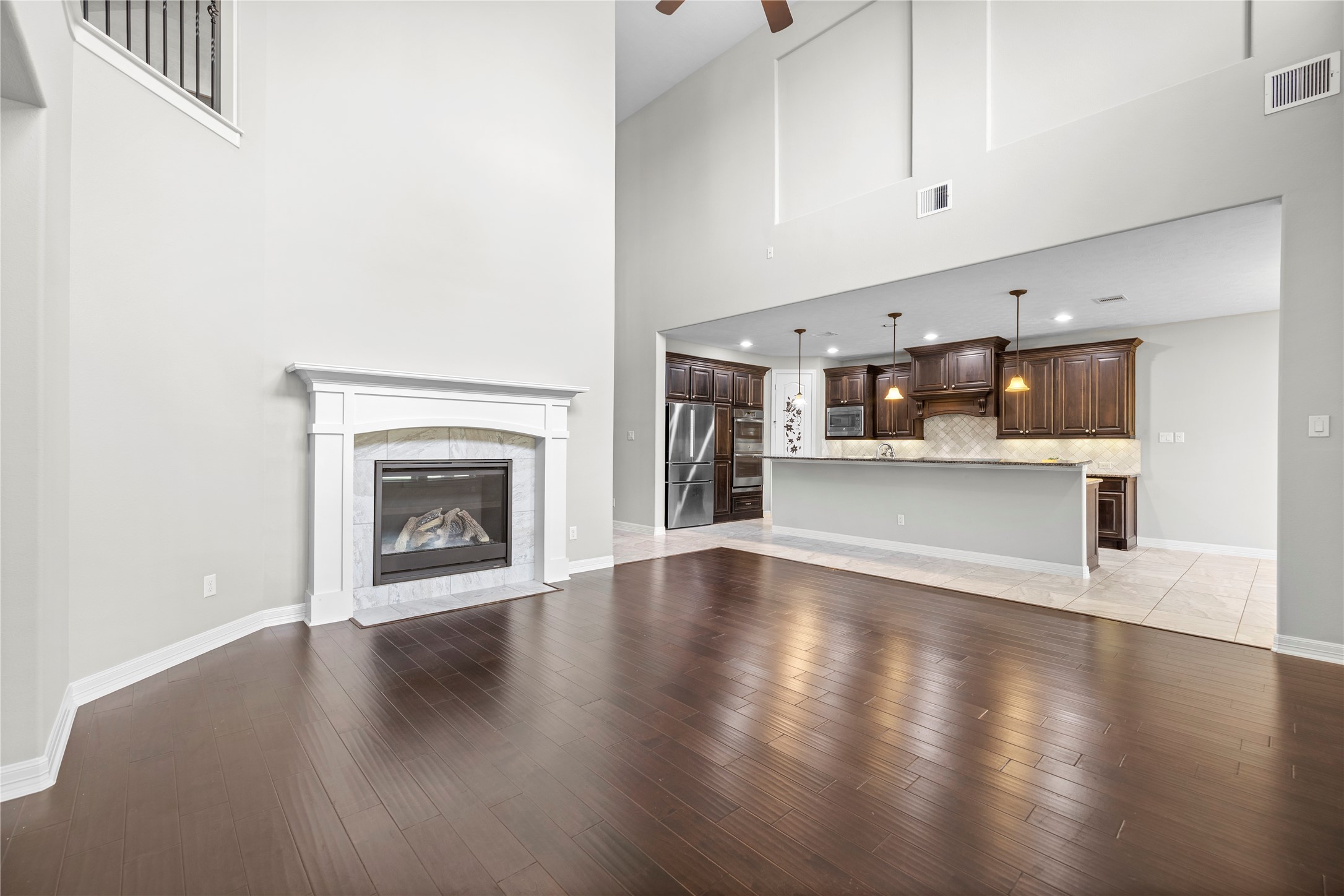 27506 Windcrest Key Lane Fulshear, TX 77441 - Photo 7 of 30 a view of a room with wooden floor and a fireplace
