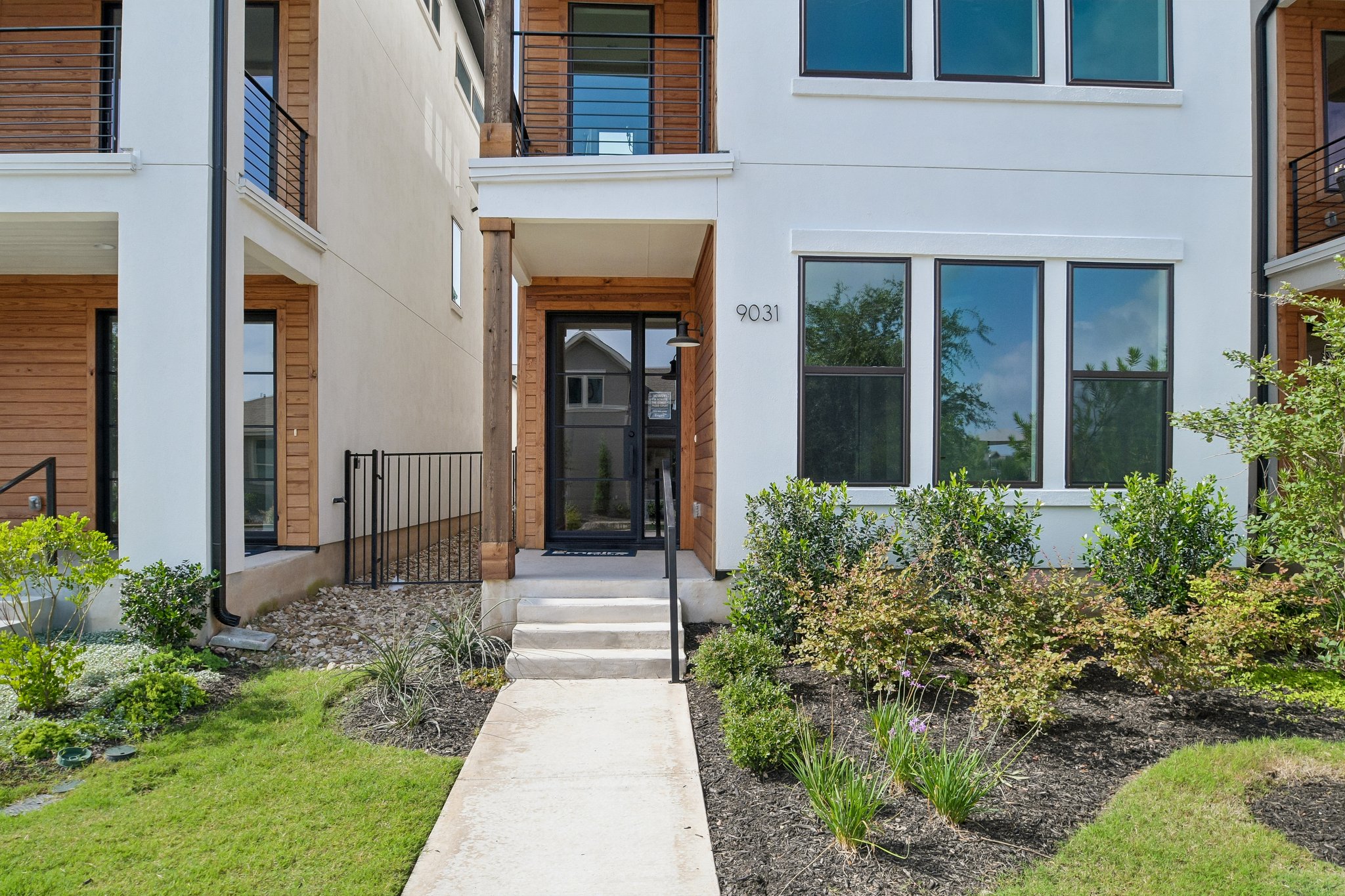 9031 Cattle Baron Path Austin, TX 78747 - Photo 4 of 31 A striking modern facade with clean lines and a welcoming concrete pathway.