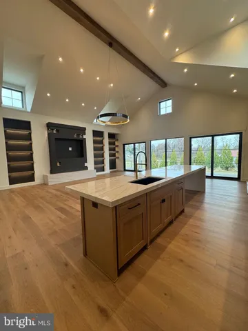 a large kitchen with stainless steel appliances a large counter top and a large window