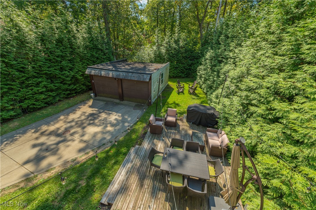 4022 Hillbrook Road Cleveland, OH 44118 - Photo 29 of 49 View of green lawn with an outbuilding, a detached garage, outdoor dining area, a deck, and outdoor lounge area