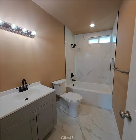 a bathroom with a bathtub shower sink vanity and toilet