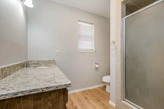 a bathroom with a granite countertop sink and toilet