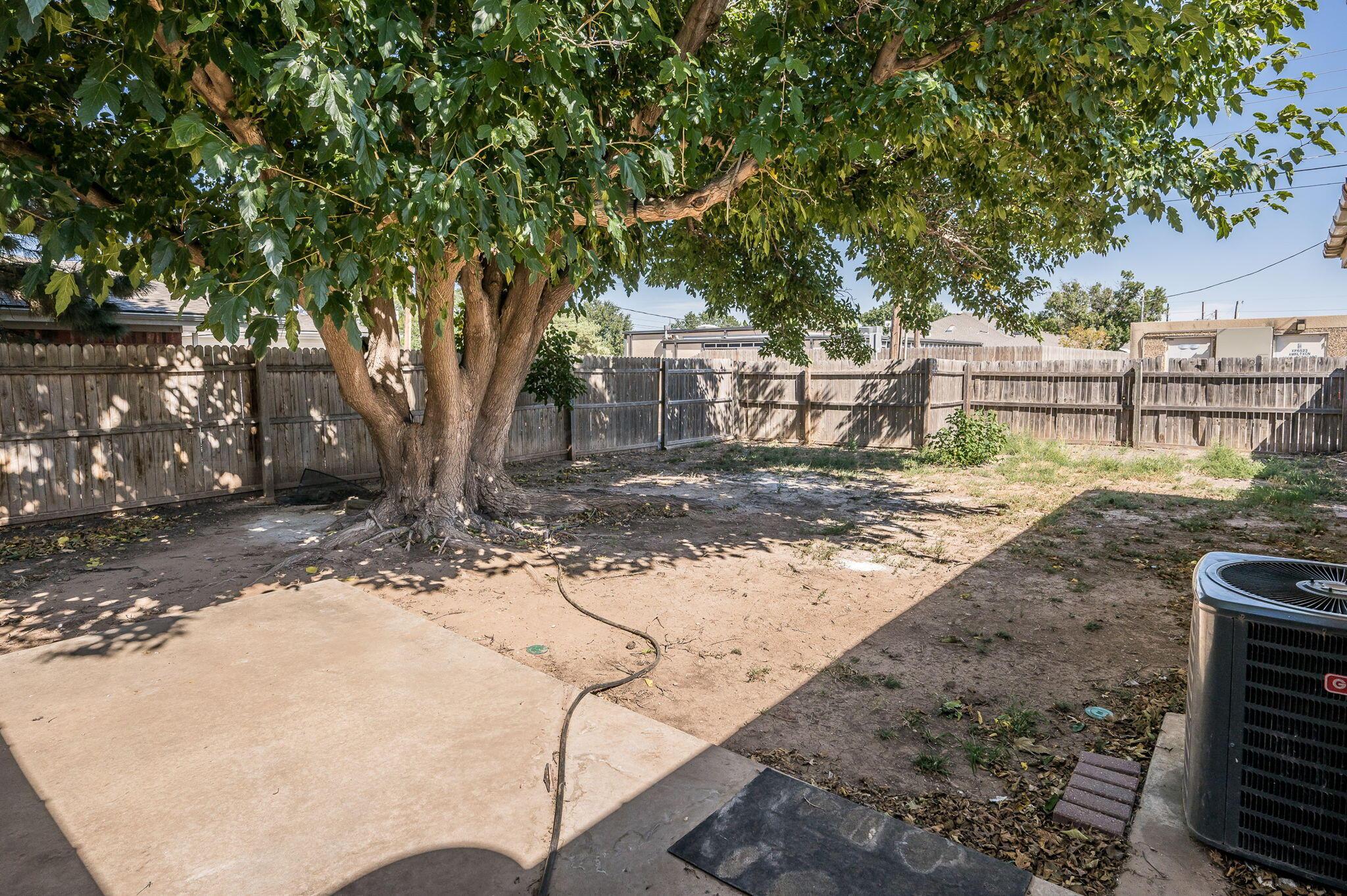 6705 Brandon Lane Amarillo, TX 79109 - Photo 16 of 20 a backyard of a house with large trees and outdoor seating