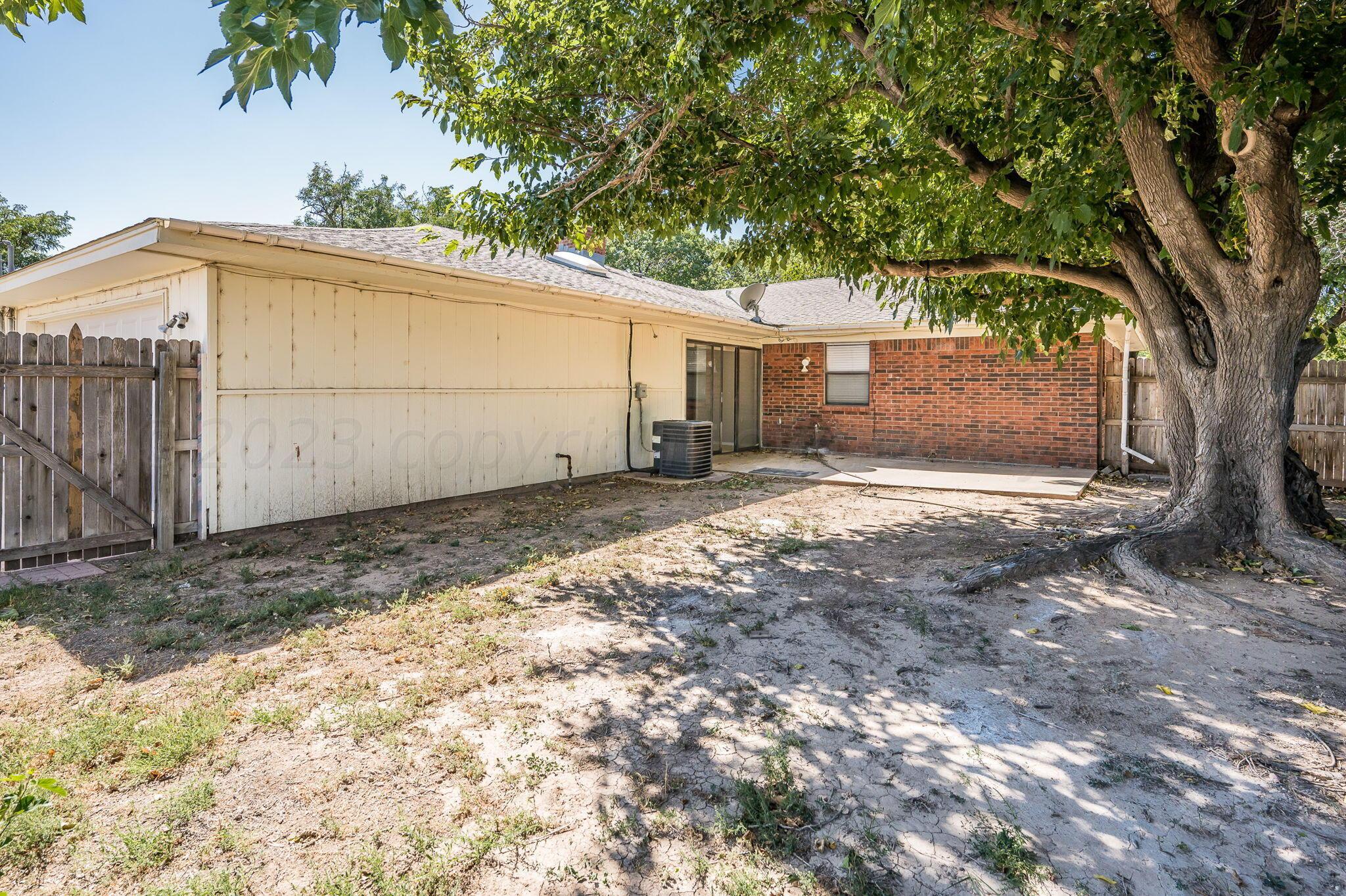 6705 Brandon Lane Amarillo, TX 79109 - Photo 17 of 20 a view of a backyard with a large tree