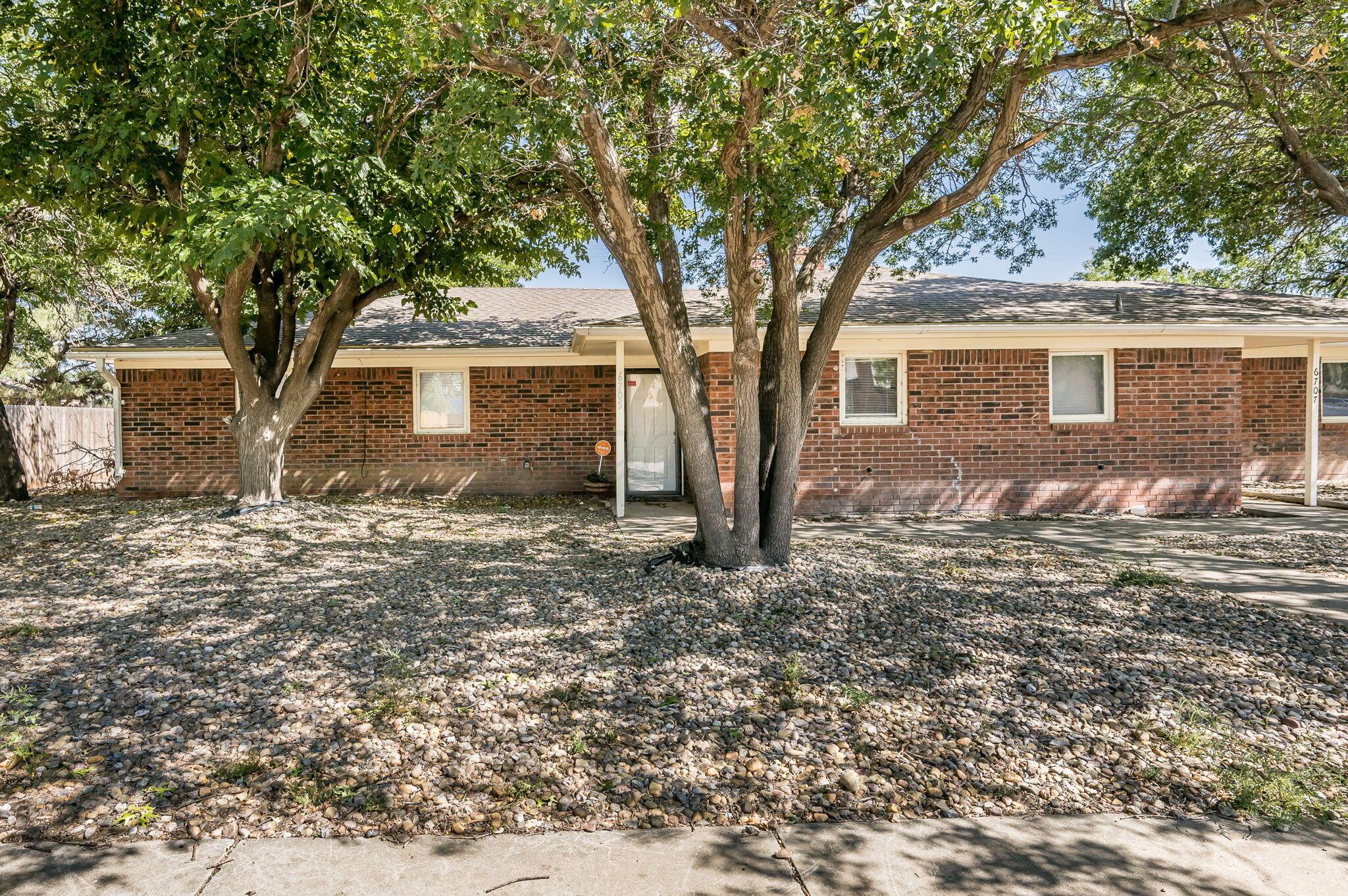 6705 Brandon Lane Amarillo, TX 79109 - Photo 2 of 20 a tree in front of a white house