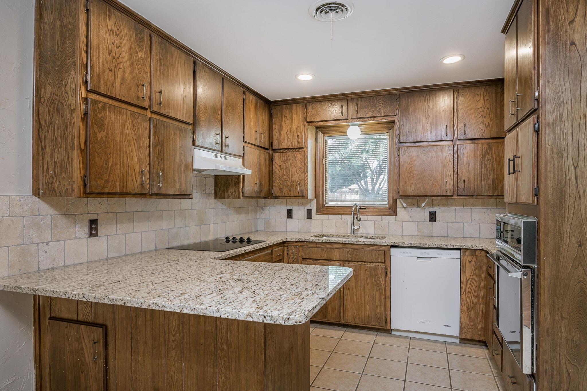 6705 Brandon Lane Amarillo, TX 79109 - Photo 6 of 20 a kitchen with stainless steel appliances granite countertop a sink a stove and a microwave