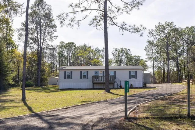 a view of a house with backyard and tree