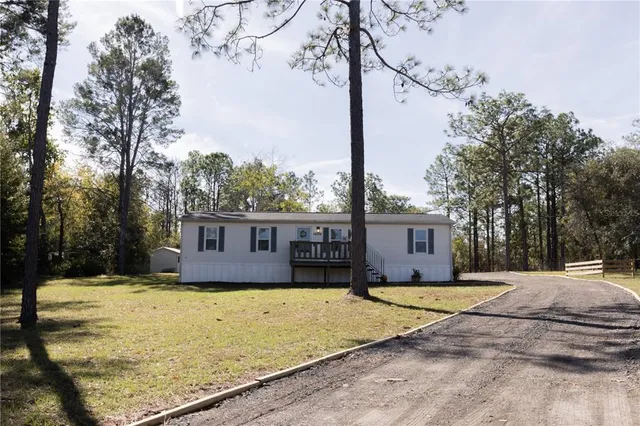 a view of a house with a yard covered in snow