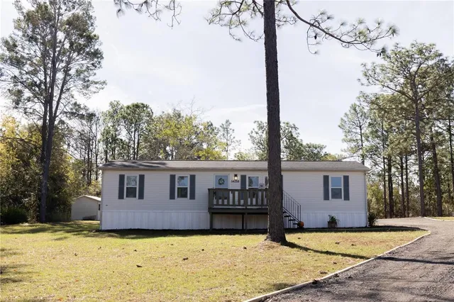 a front view of a house with a yard and trees