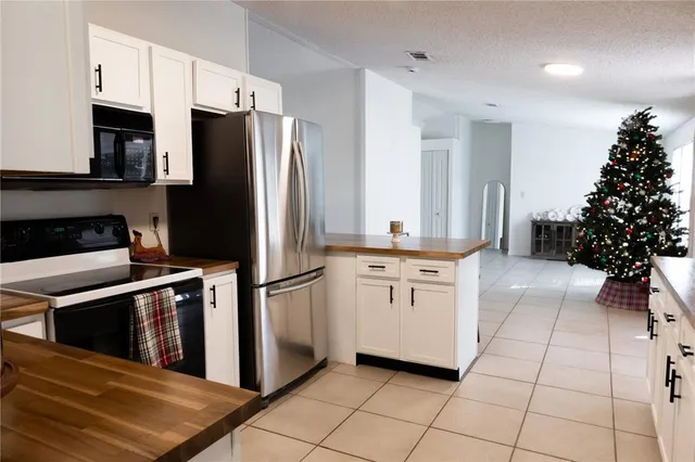 a kitchen with granite countertop a refrigerator and a stove top oven
