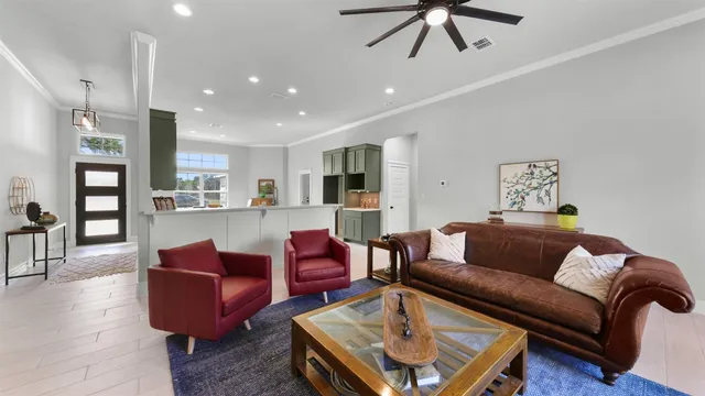 a living room with furniture kitchen view and a chandelier