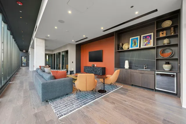 a living room with furniture a flat screen tv and kitchen view