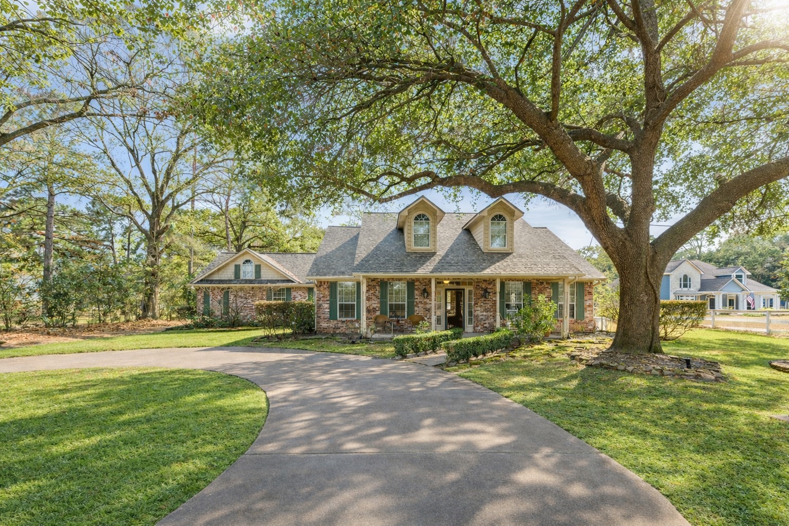 22625 Tomball Cemetery Road Tomball, TX 77377 - Photo 1 of 32 Charming single-story home with a beautiful stone facade and a welcoming front porch. It features a large, mature tree providing shade to the front yard and a curved driveway leading to the entrance. The neighborhood appears peaceful and well-maintained.