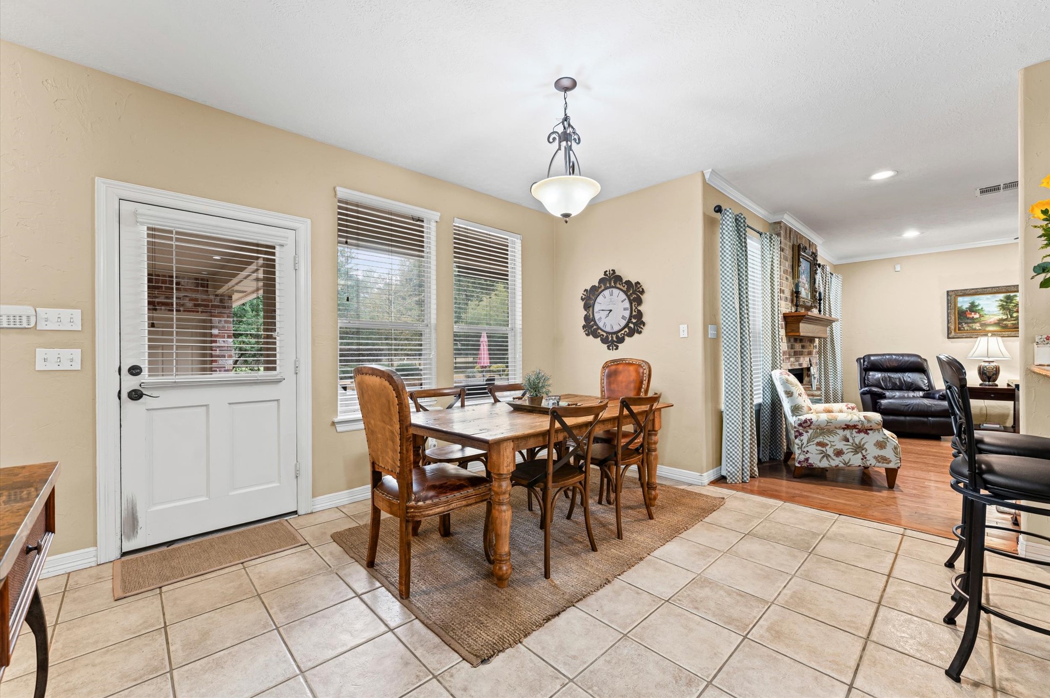 22625 Tomball Cemetery Road Tomball, TX 77377 - Photo 13 of 32 This inviting dining area features large windows for natural light and an open layout leading to a comfortable living room with a fireplace. The neutral tones and tile flooring create a warm, welcoming atmosphere.