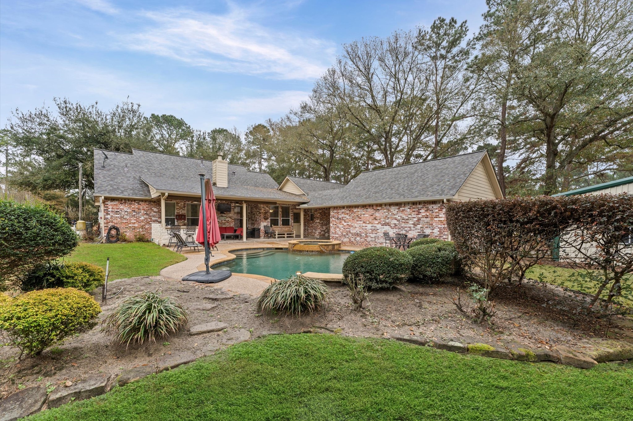 22625 Tomball Cemetery Road Tomball, TX 77377 - Photo 27 of 32 Charming brick home with a spacious backyard featuring a PebbleTech Pool, patio area, and well-maintained landscaping. Ideal for outdoor relaxation and entertaining.
