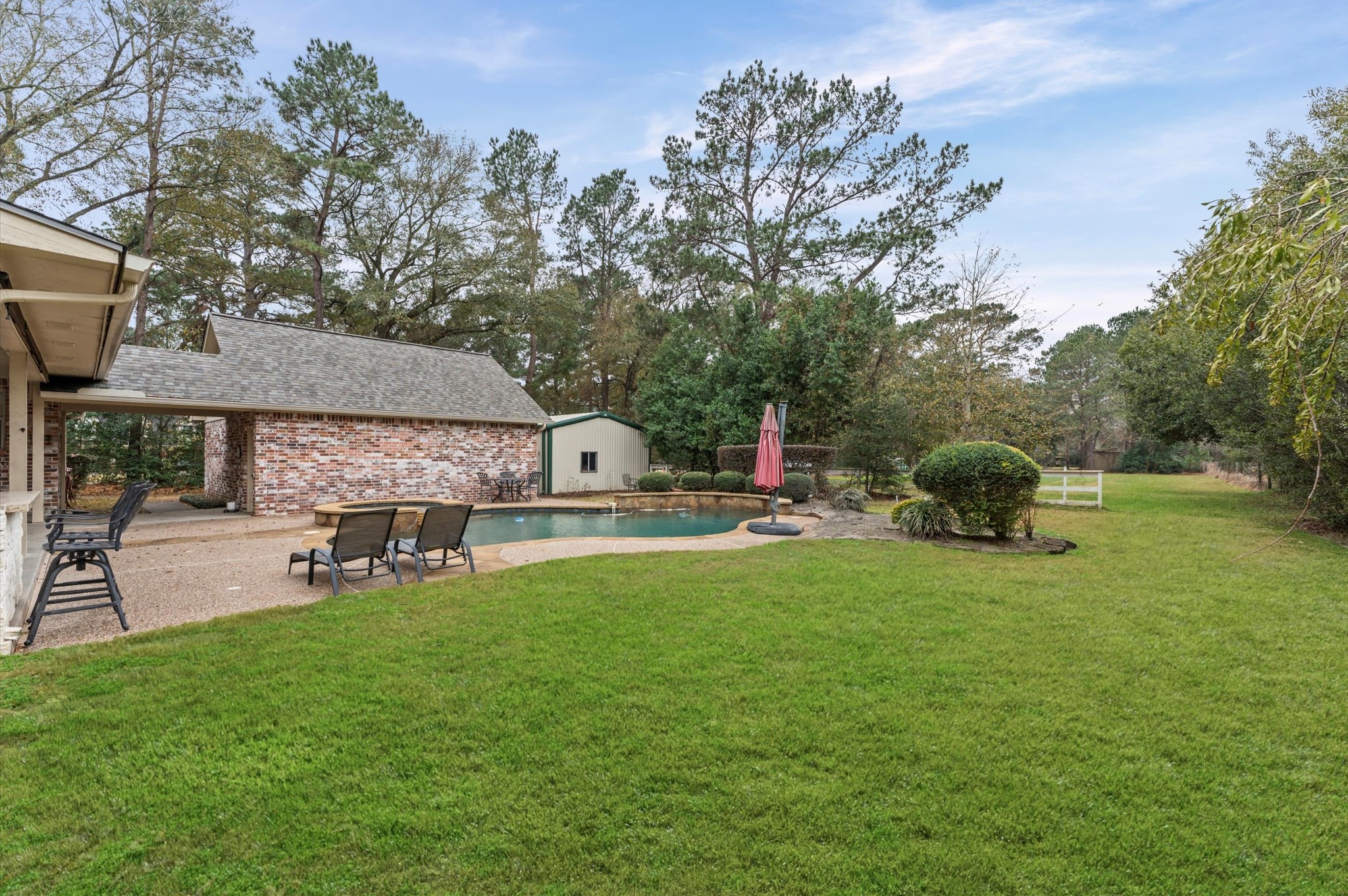 22625 Tomball Cemetery Road Tomball, TX 77377 - Photo 29 of 32 This backyard features a spacious lawn for outdoor relaxation. Surrounded by mature trees, it offers privacy and a serene atmosphere ideal for entertaining or unwinding.