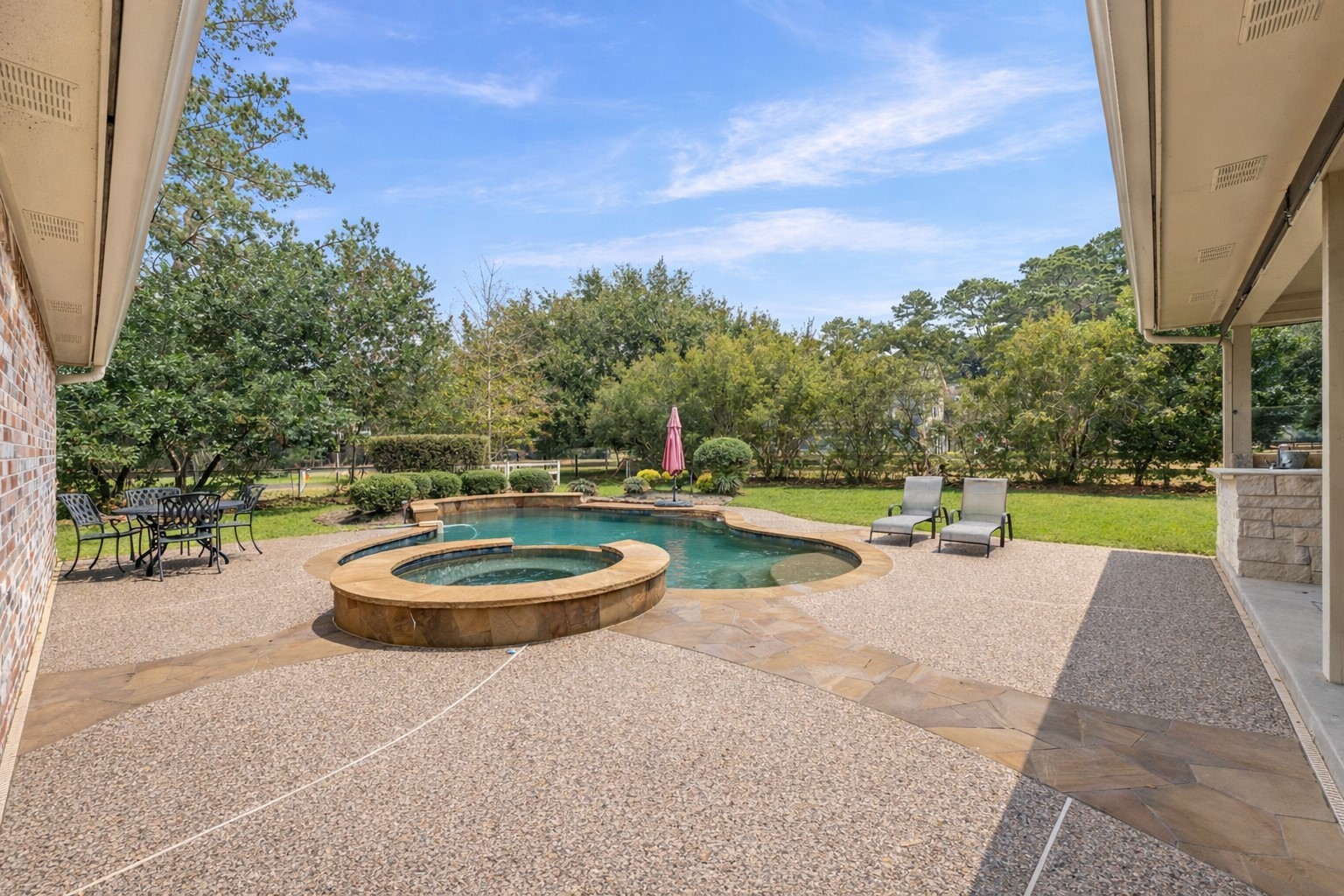 22625 Tomball Cemetery Road Tomball, TX 77377 - Photo 6 of 32 Spacious backyard with a beautiful pool and hot tub, surrounded by a large patio area. There's ample seating for relaxation and dining, set against a backdrop of lush greenery for privacy and tranquility.