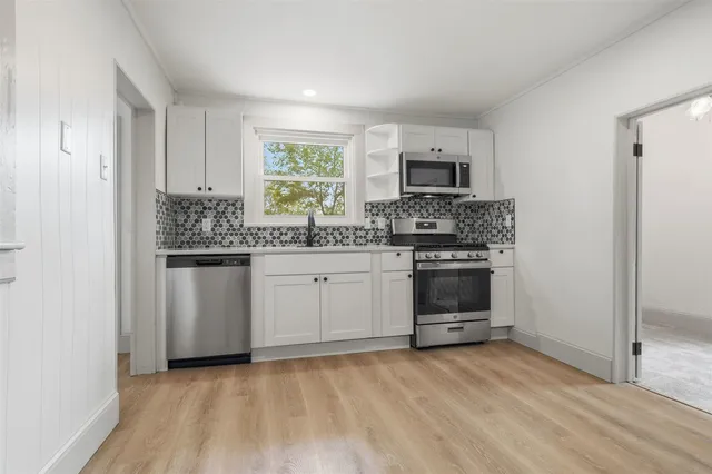 a kitchen with stainless steel appliances granite countertop a stove a sink and a refrigerator