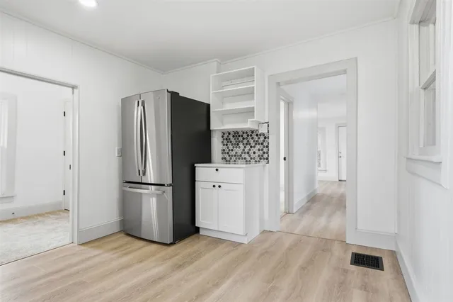 a kitchen with a refrigerator and a stove top oven