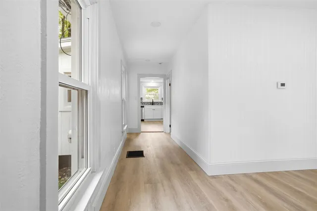 a view of a hallway with wooden floor and staircase