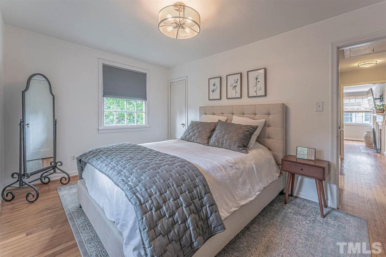 1113 Norris Street Raleigh, NC 27604 - Photo 22 of 29 a bedroom with a bed and a chandelier