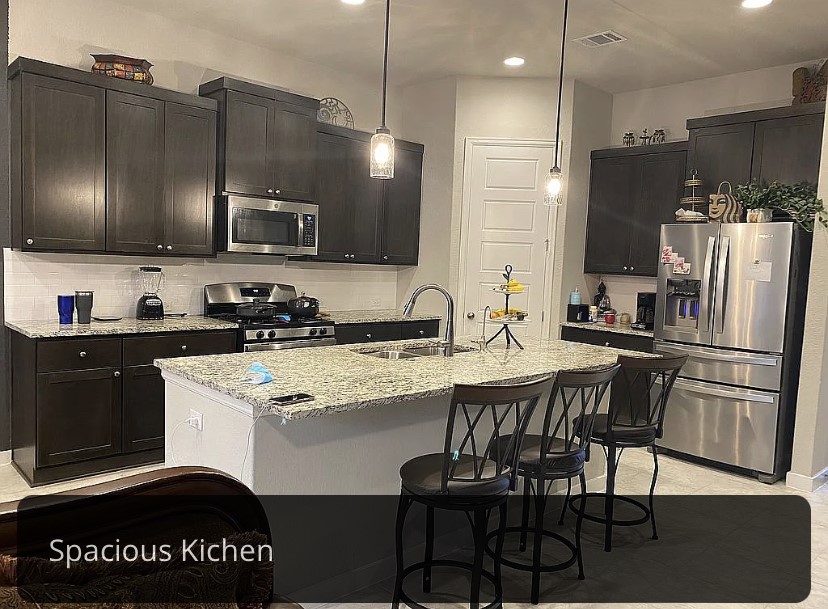 2017 Palmera Ridge Boulevard Leander, TX 78641 - Photo 10 of 17 a kitchen with a refrigerator a microwave a stove and a sink