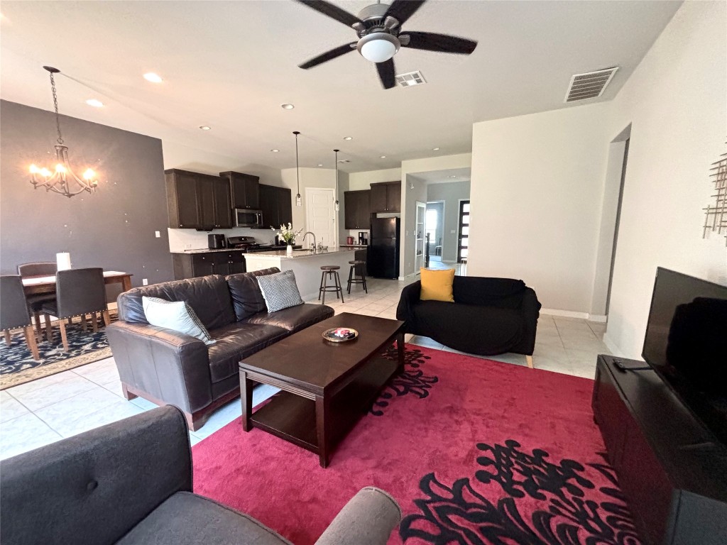 2017 Palmera Ridge Boulevard Leander, TX 78641 - Photo 12 of 17 a living room with furniture a flat screen tv and a refrigerator