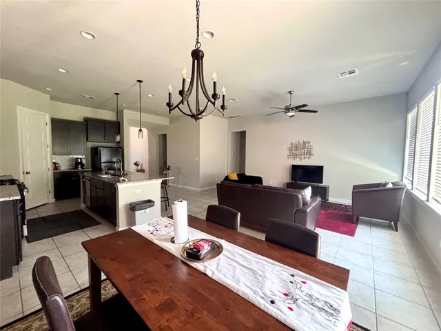 a living room with furniture a flat screen tv and a refrigerator