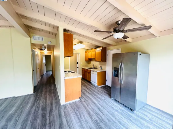 a view of a kitchen with stainless steel appliances wooden floor