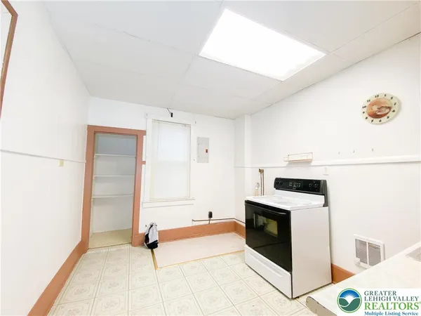 a kitchen with stainless steel appliances white cabinets and wooden floor