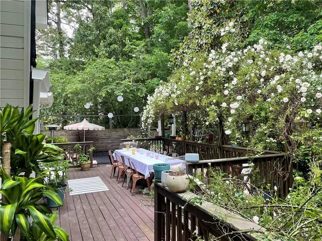 a view of a hallway with wooden floor and a bathroom