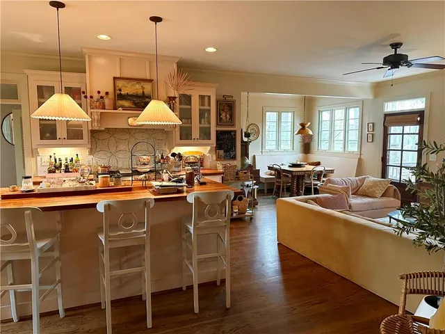 a view of a hallway with wooden floor and a bathroom