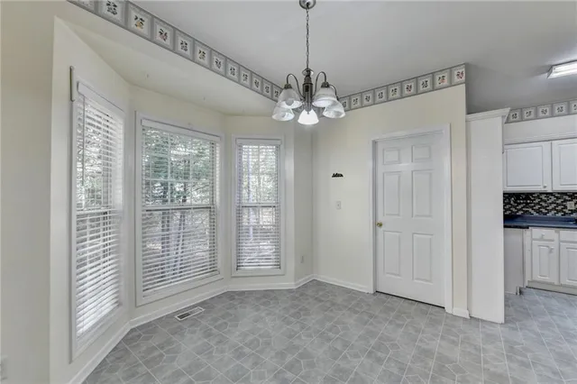 a view of a livingroom with a chandelier a ceiling fan and window
