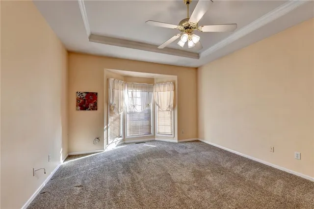 an empty room with fan and windows