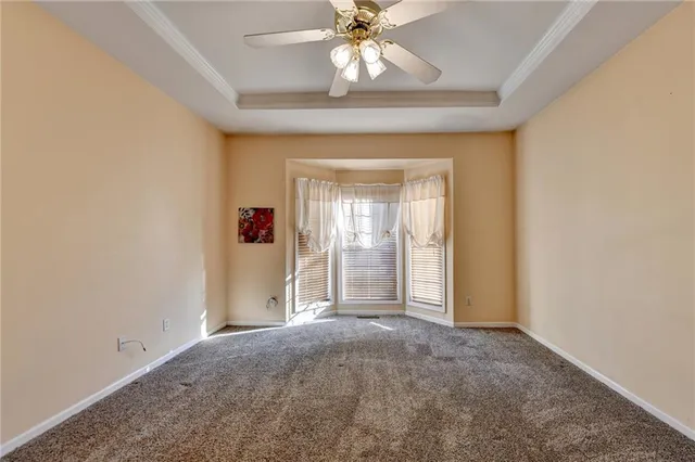an empty room with fan and windows