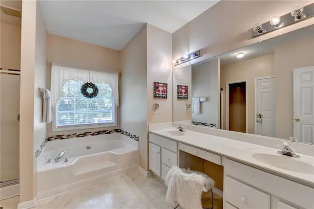 a spacious bathroom with a tub sink and mirror
